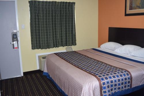 a hotel room with a bed and a window at White Oaks Motel Pennsville/Carneys Point in Pennsville