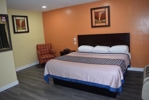 a hotel room with a bed and a chair at White Oaks Motel Pennsville/Carneys Point in Pennsville