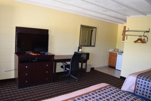 a hotel room with a desk and a television at White Oaks Motel Pennsville/Carneys Point in Pennsville