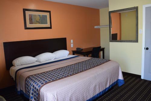 a hotel room with a bed and a mirror at White Oaks Motel Pennsville/Carneys Point in Pennsville