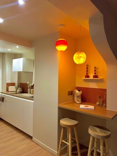 - une cuisine avec deux tabourets de bar et deux lumières dans l'établissement Moon Room, Nuit insolite - Ollioules Toulon Var, à Ollioules
