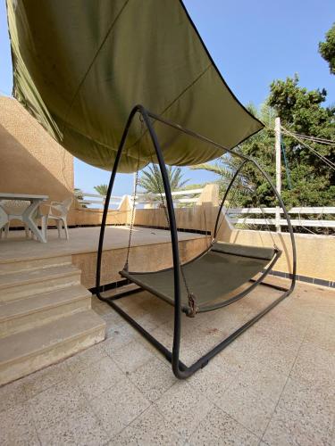 a large umbrella sitting on top of a patio at Duplex pied dans l'eau avec magnifique vue sur mer in Monastir