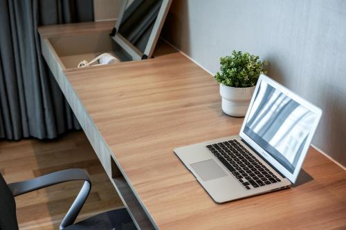 a laptop computer sitting on top of a wooden desk at Dorsett Changi City Singapore in Singapore