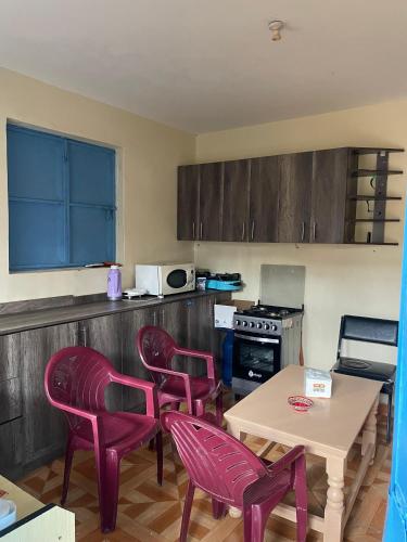 a kitchen with purple chairs and a table and a table and a table at Future Stars Centre Kibera in Nairobi