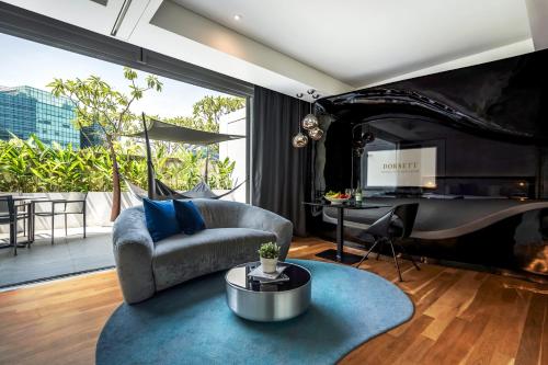 a living room with a couch and a table at Dorsett Changi City Singapore in Singapore