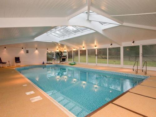a large swimming pool in a building with a ceiling at Country Home on Private Estate in Minishant