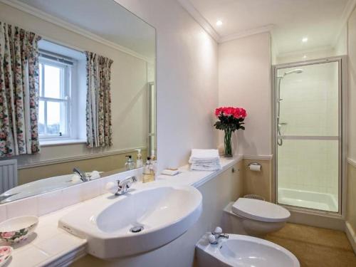 a bathroom with two sinks and a toilet and a mirror at Country Home on Private Estate in Minishant