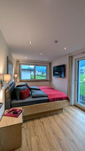 a bedroom with a large bed and a large window at Penzhaus - Premium Private Suites in Zell am Ziller