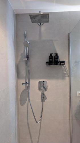a shower with a shower head in a bathroom at Penzhaus - Premium Private Suites in Zell am Ziller