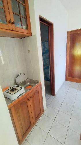 a kitchen with a sink and a counter top at Pensão Alcinda Bettencourt 100 meters to the Beachfront in Santa Maria