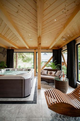 a large room with a large tub and a couch at Chałupa na wsi u Papierzy Sauna, Jacuzzi, SPA in Witów