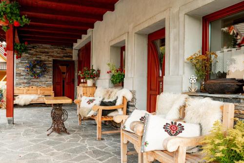 a patio with couches and a table and chairs at Chałupa na wsi u Papierzy Sauna, Jacuzzi, SPA in Witów