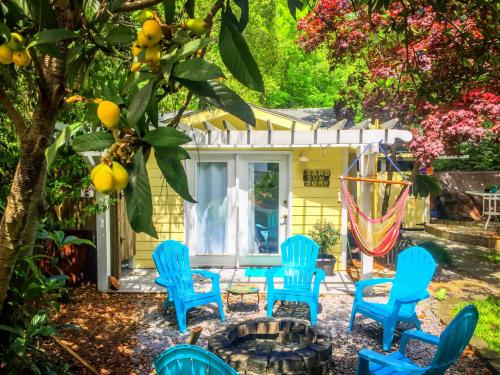 a group of blue chairs in front of a yellow house at Romantic Beach Style Cottage close to everything! in Whitehouse Plantation