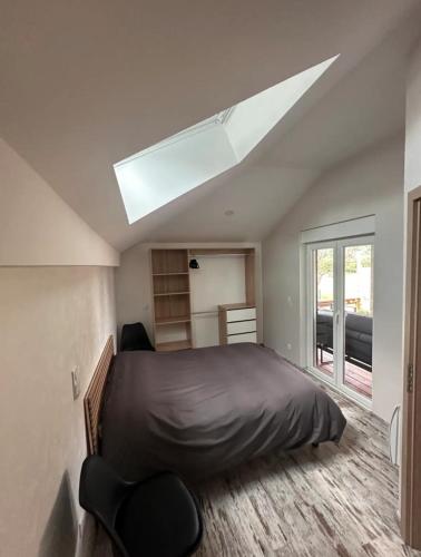 - une chambre avec un grand lit et une lucarne dans l'établissement Ô Ptit Bouleau, à Buhl-Lorraine