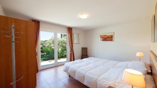 a bedroom with a bed and a large window at Villa Alize in Vallon-Pont-dʼArc