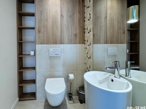 a bathroom with a white toilet and a sink at AMuSE ME in Kielce