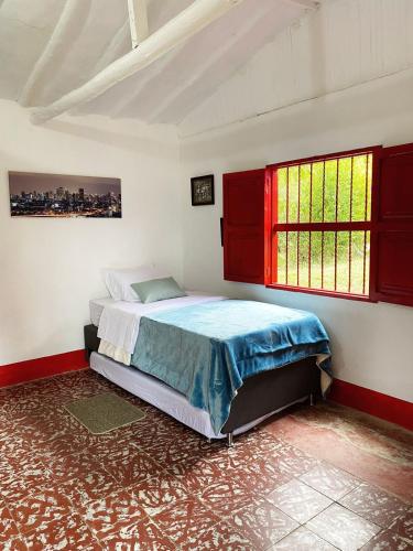 a bedroom with a bed and two windows in it at Casa De Campo "Las Chispas" in Medellín