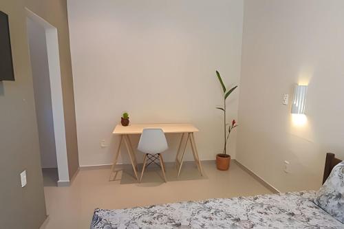 a table and a chair in a room with a bed at Vila Boulevard Aconchegante in Manaus