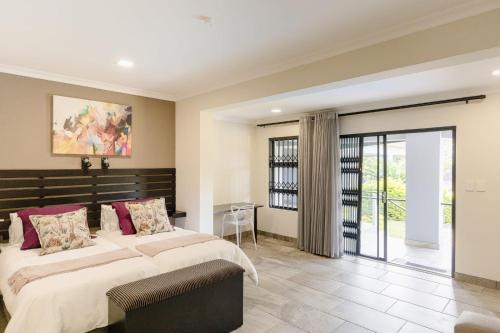 a bedroom with two beds and a balcony at 8 On Eagle Bed & Breakfast Room 2 in Port Shepstone