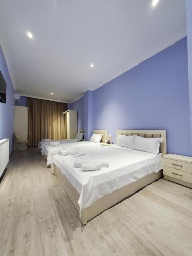 a bedroom with four beds with blue walls at Hotel N in Tskaltubo