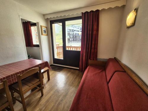 Cette chambre comprend une table, un canapé et une fenêtre. dans l'établissement Résidence Hameau Du Borsat 1& 2 - Appartement résidence Hameau du Borsat MAE-7524, à Tignes