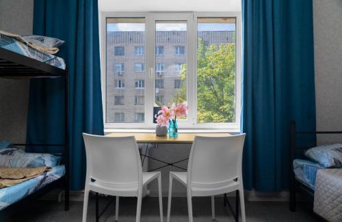 a dining room table with two chairs and a window at Хостел єЖитло Щекавиця in Kyiv
