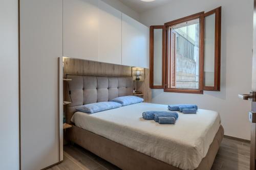 Un dormitorio con una cama con dos almohadas azules encima. en Perseo case vacanze Mameli Apartment, en Olbia