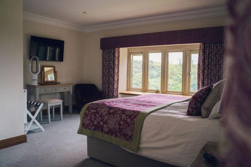 a bedroom with a large bed and a window at The Manor Boutique Hotel Restaurant and Bar in Conwy