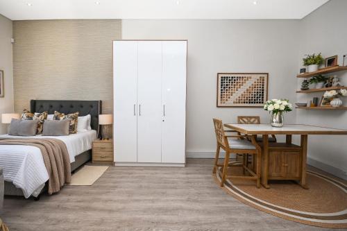 Un dormitorio con una cama, una mesa y un escritorio. en 308 on Titanium, en Strand