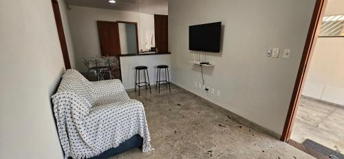 a living room with a chair and a tv at Casa BNH in Cachoeiro de Itapemirim