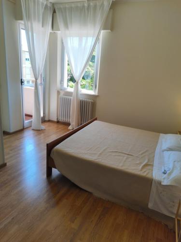 a bedroom with a bed and two windows at Il Vecchio Calzaturificio in Civitanova Marche