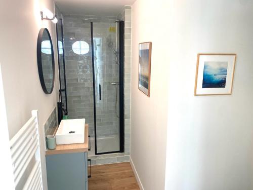 une salle de bain avec douche et lavabo dans l'établissement Appartement avec Terrasse proche du Centre-ville, à La Rochelle