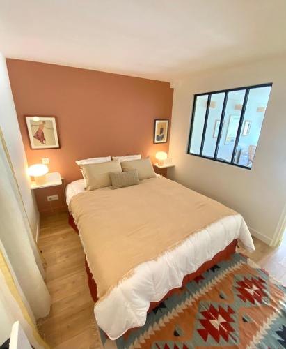 une chambre avec un grand lit et une fenêtre dans l'établissement Appartement avec Terrasse proche du Centre-ville, à La Rochelle