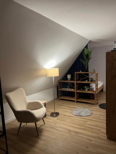 a living room with a chair and a lamp at FeWo Foorden Wohnglück 2 in Hesel