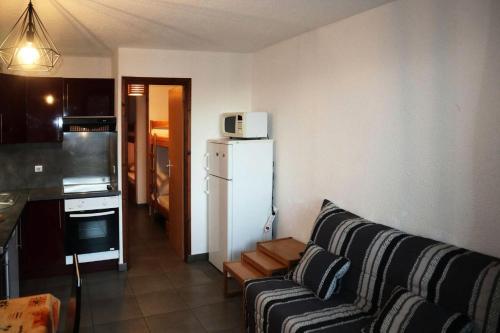 - un salon avec un canapé et un réfrigérateur blanc dans l'établissement Résidence Le Cairn - COEUR DE STATION - Les Orres 1650 Résidence CAIRN - Studio 6 personnes MAE-4561, aux Orres
