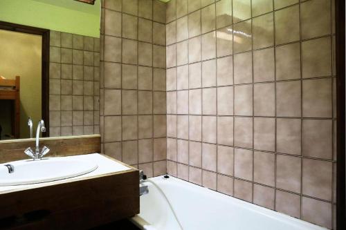 La salle de bains est pourvue d'un lavabo et d'une baignoire à côté d'une douche. dans l'établissement Résidence Le Cairn - Résidence Cairn - Studio 4 personnes vue pistes MAE-6351, aux Orres