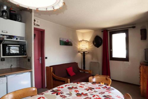 une cuisine et une salle à manger avec une table et une chaise dans l'établissement Résidence Le Cairn - APPARTEMENT 6 PERSONNES N° 506 CAIRN MAE-6341, aux Orres