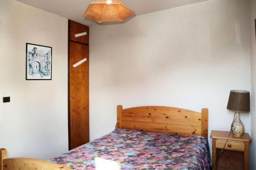 une chambre avec un lit et une lampe sur une table dans l'établissement Résidence Le Cairn - APPARTEMENT 6 PERSONNES N° 506 CAIRN MAE-6341, aux Orres