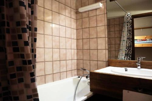 une salle de bain avec une baignoire et un lavabo et une baignoire dans l'établissement Résidence Le Cairn - APPARTEMENT 6 PERSONNES N° 506 CAIRN MAE-6341, aux Orres