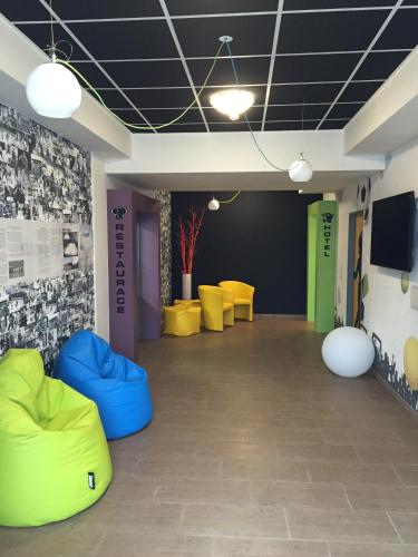 a room with yellow and blue chairs and a flat screen tv at Sport hotel Sletiště in Kladno