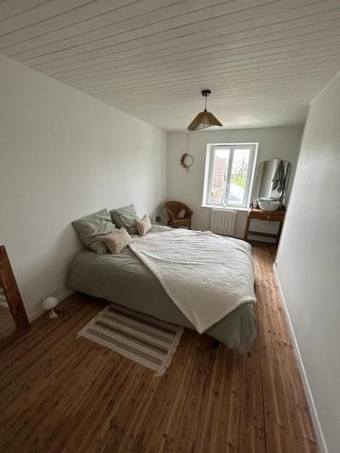 une chambre avec un lit dans une pièce blanche dans l'établissement Maison Portbail sur Mer, à Denneville