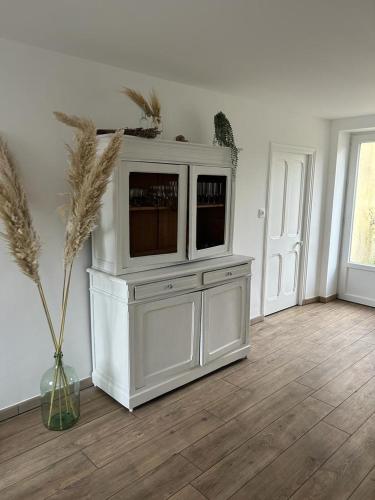 - un centre de divertissement blanc avec une télévision dans le salon dans l'établissement Maison Portbail sur Mer, à Denneville