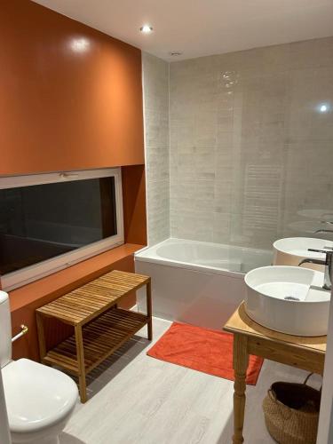 une salle de bain avec une baignoire, un lavabo et des toilettes dans l'établissement Maison Portbail sur Mer, à Denneville