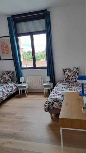 Cette chambre comprend deux lits et une grande fenêtre. dans l'établissement Appartement Miami près de Douai, à Flers-en-Escrebieux