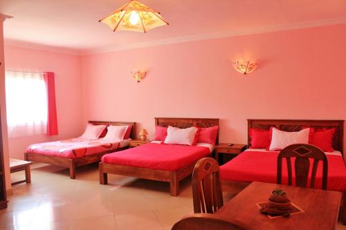 a living room with two beds and a table at K.méléon-Hôtel in Ivato