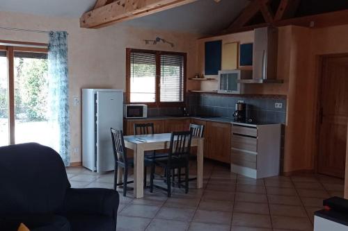 une cuisine avec une table, des chaises et un réfrigérateur dans l'établissement Chalet 2 chambres en Savoie pour 1 à 4 personnes, à Gerbaix