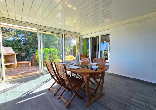 une salle à manger avec une table et des chaises en bois dans l'établissement Les Muratiers T2 - Bord de mer - Terrasse - Clim, à Hyères