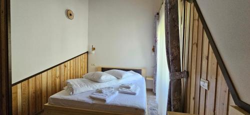 a bedroom with a bed with towels on it at Cabana dintre Salcami in Durau