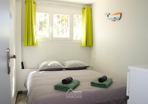 - une chambre avec un lit et 2 serviettes vertes dans l'établissement Les Muratiers T2 - Bord de mer - Terrasse - Clim, à Hyères