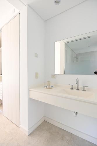 a white bathroom with a sink and a mirror at Carilo Vista in Carilo